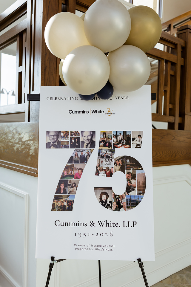 Welcome display featuring a 75th Anniversary photo collage and gold balloons at Cummins & White’s anniversary celebration.