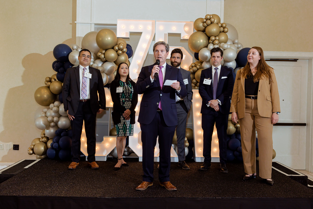 Managing Partner Fred Whitaker addresses guests alongside members of Cummins & White’s next generation of leadership during the firm’s 75th Anniversary celebration.