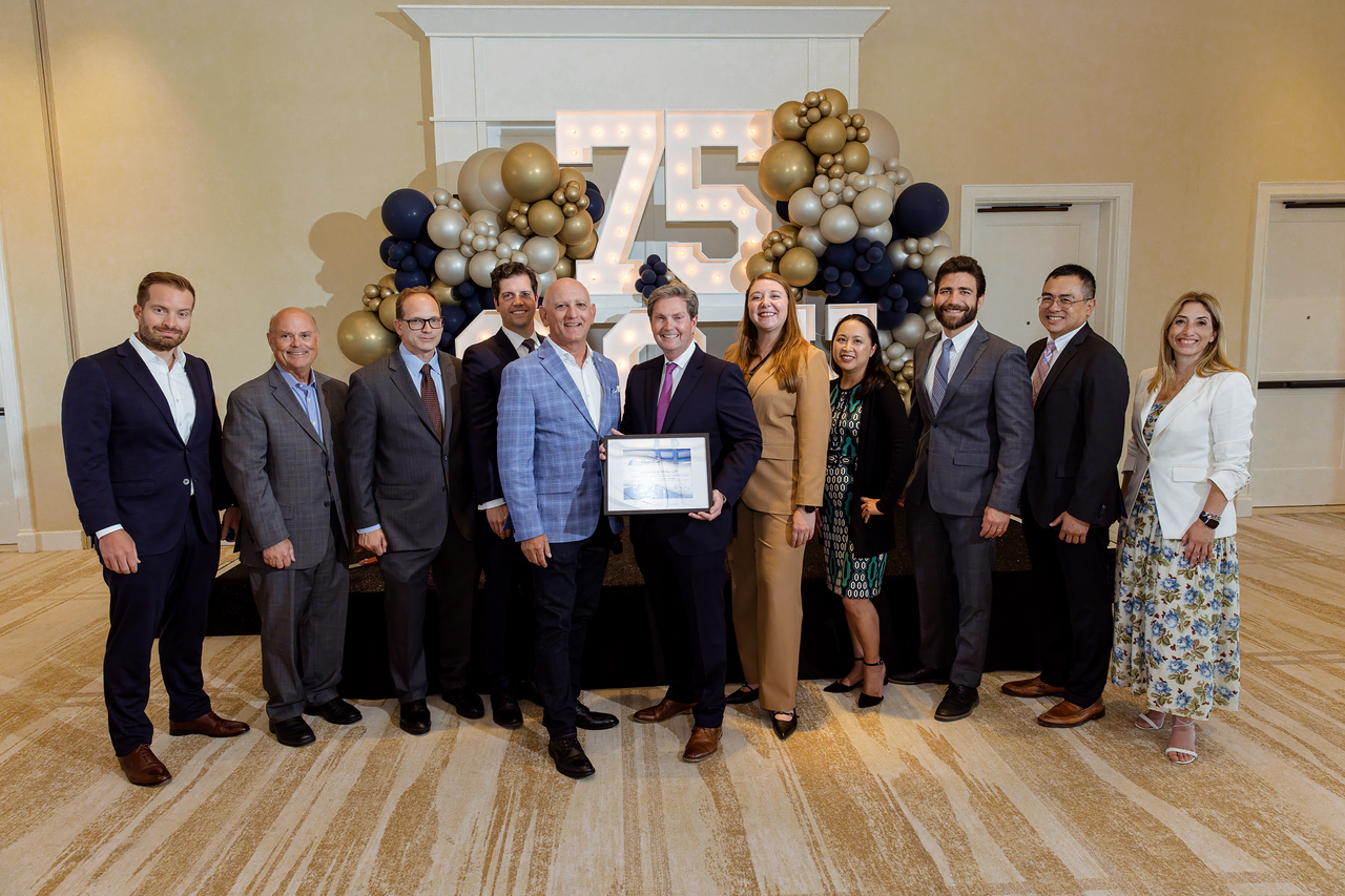 Newport Beach Chamber of Commerce President Steve Rosansky, members of the Newport Beach City Council, and Cummins & White partners display a certificate recognizing the firm’s 75th Anniversary.